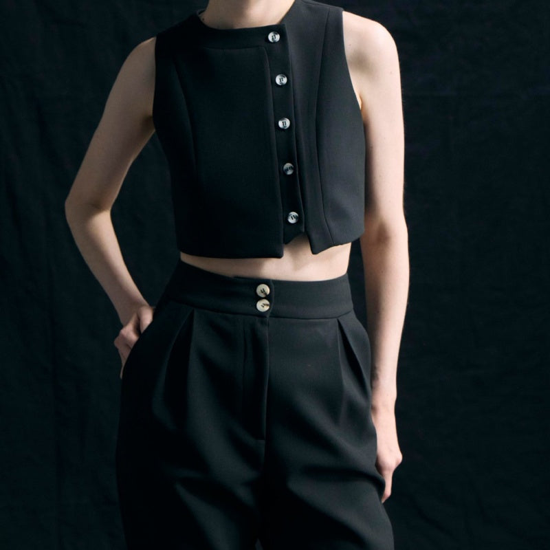 Elegante outfit da donna in 2 parti con un top senza maniche e pantaloni con una vita alta